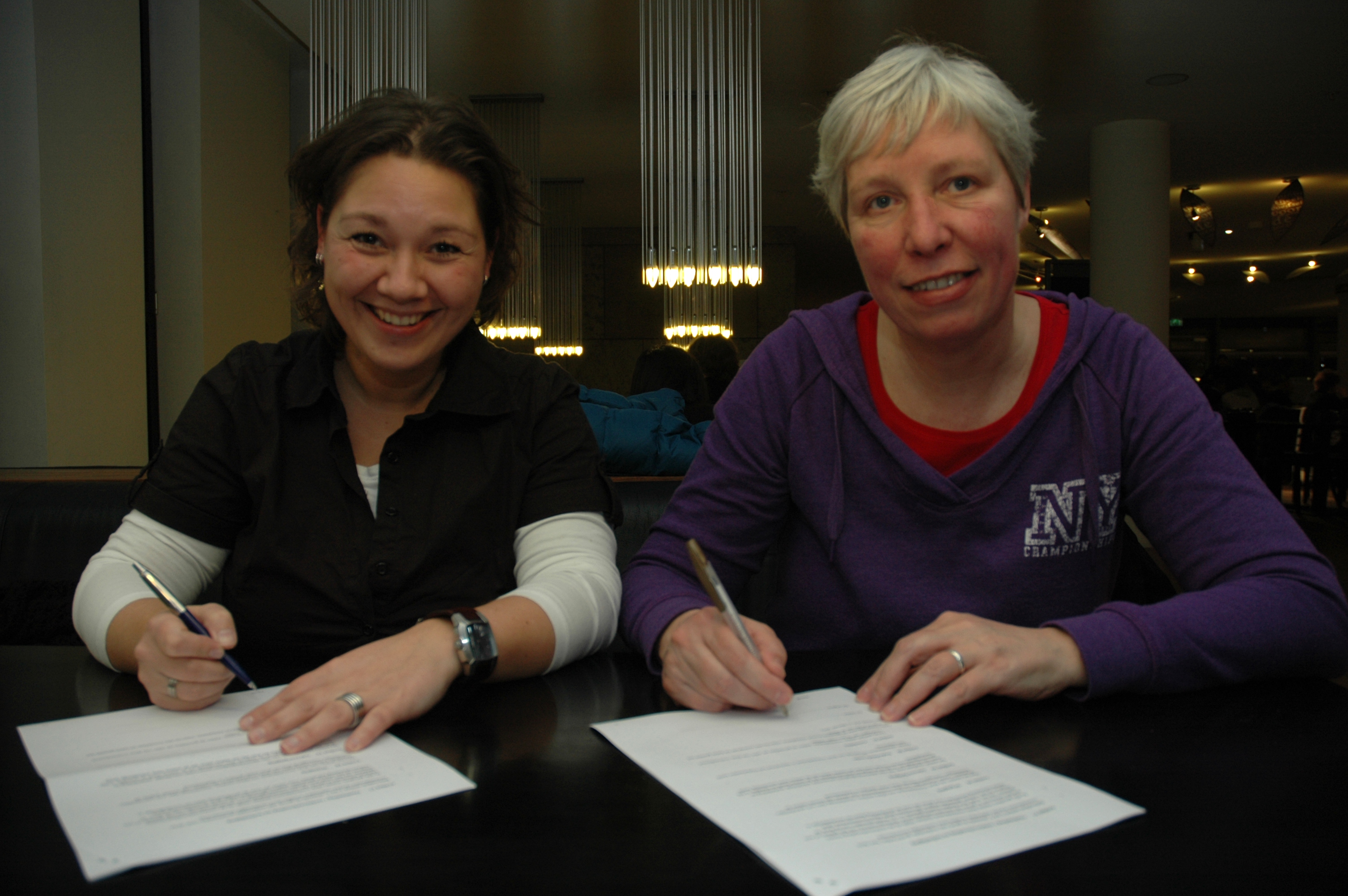 Suzanne Gerding en Hilda Abbing tekenen het contract voor publicatie van het winnende manuscript